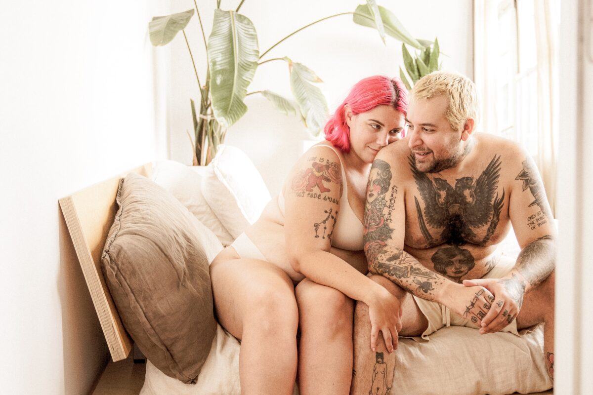 Un couple en sous-vêtements assis sur le bord d'un lit.